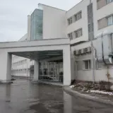 Exteriorul unei clădiri de spital moderne, cu mai multe etaje, albă, având o intrare principală sub o copertină masivă