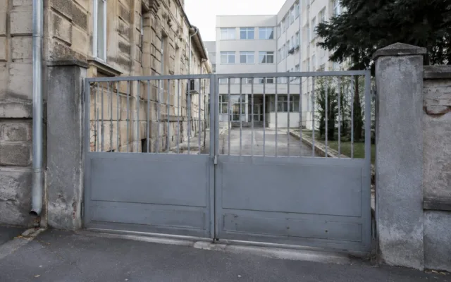 Poartă metalică și clădire veche